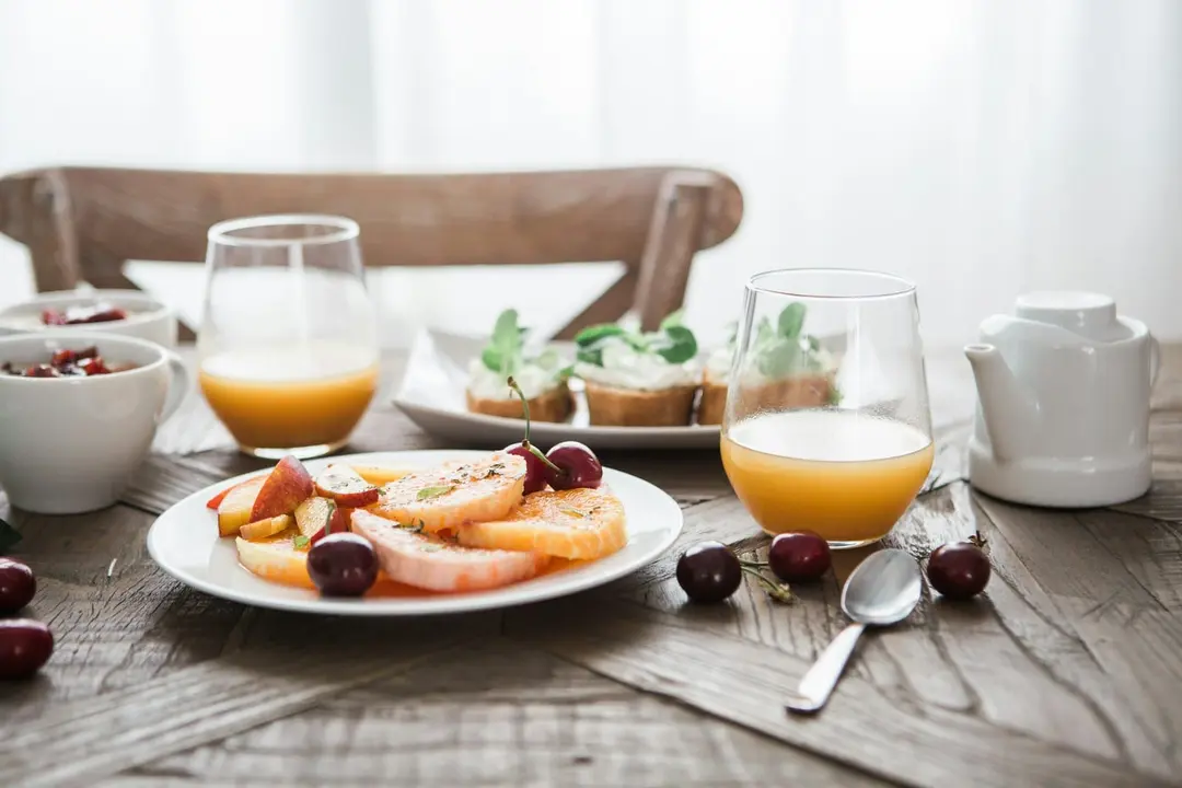 Frühstückstisch mit frischem Obst, Saft und Brot aus der Region